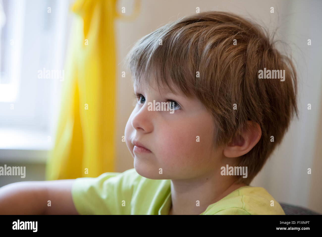 Un bambino che guarda e ascolta attentamente Foto Stock