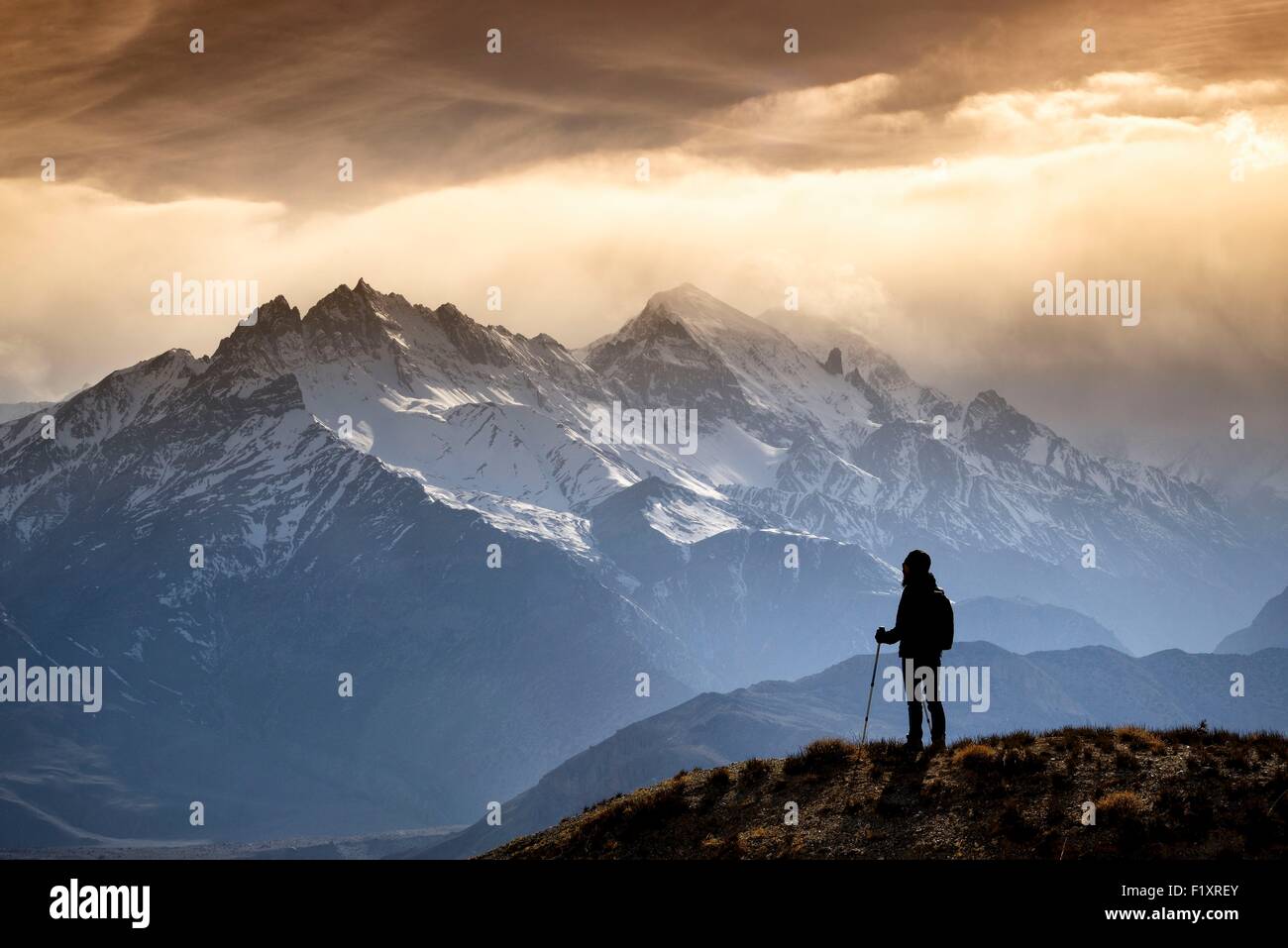 Il Nepal, Gandaki zona, Mustang superiore (vicino al confine con il Tibet), silhouette di un trekker guardando le montagne in serata della luce del sole Foto Stock