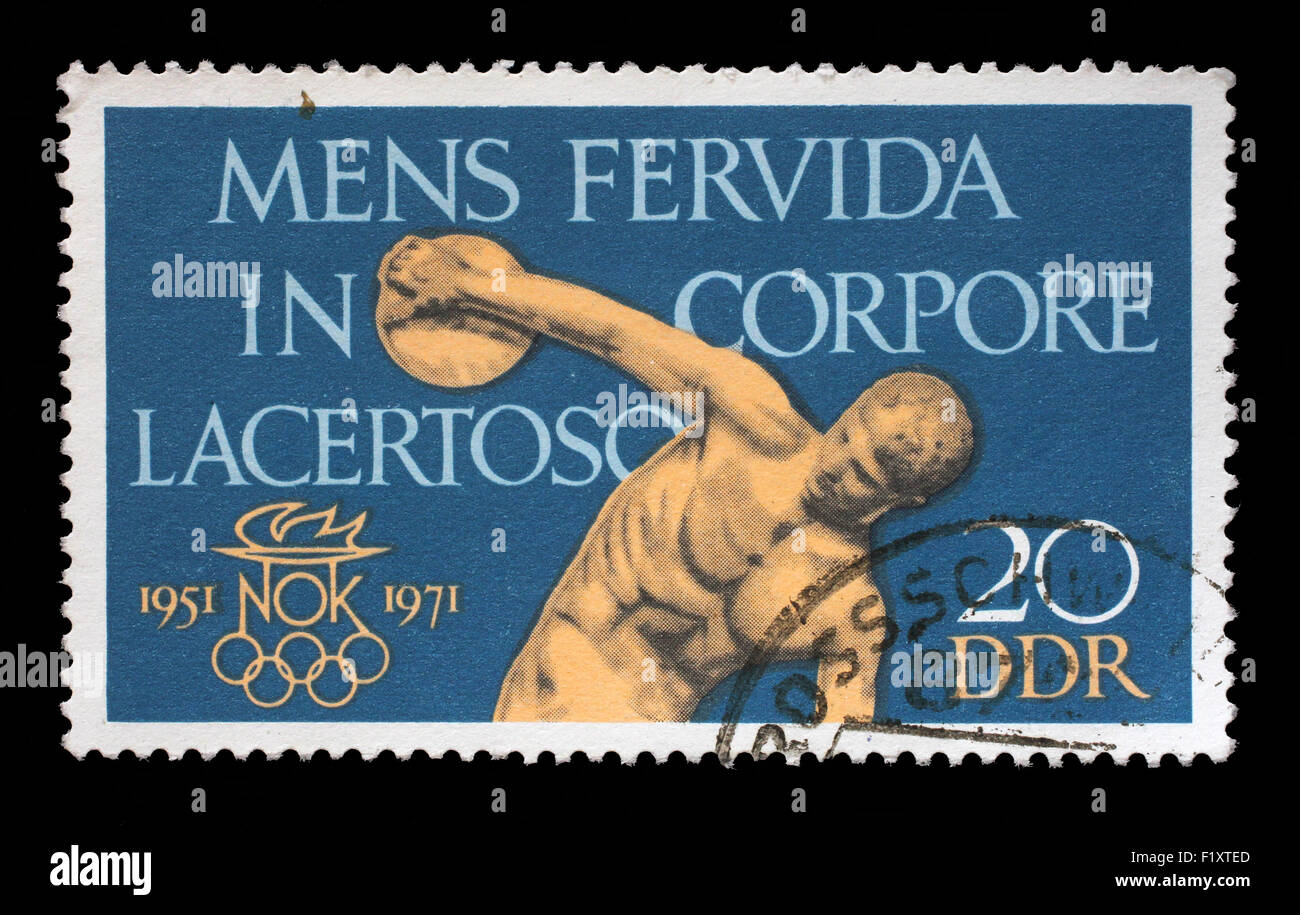Timbro stampato nella RDT mostra il ventesimo anniversario della DDR di comitato olimpico, Discobolo,, un ardente spirito in un Foto Stock