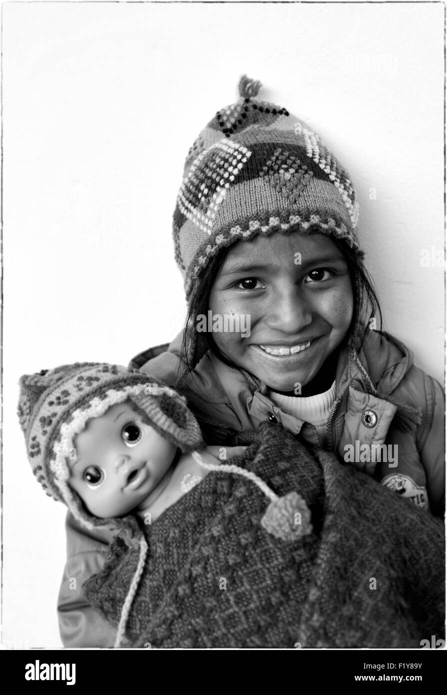 Il Perù, provincia di Cuzco, Cuzco, elencato come patrimonio mondiale dall UNESCO, TOE Huanacchire, ragazza della Ninos Unidos Peruanos Charitable Foundation indossando una lana di alpaca cofano e sua bambola Foto Stock