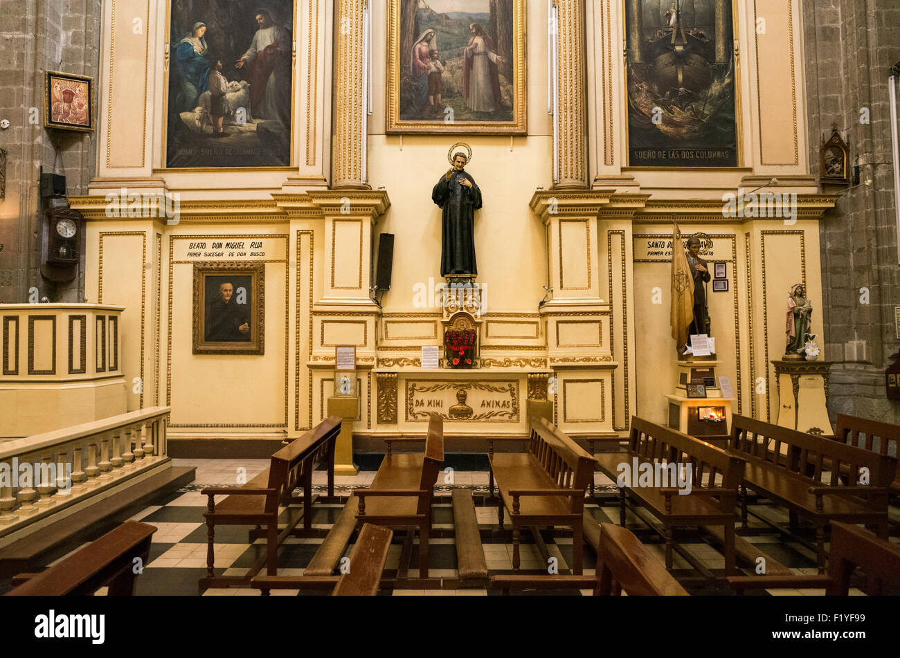 Iglesia De Santa Inés Nave Mexico City | CITTA' DEL MESSICO, Messico — Panche di legno vuote si affacciano su una cappella laterale dedicata a San Giovanni Bosco all'interno dell'Iglesia de Santa Inés, una ex chiesa conventuale nel Centro Histórico ricostruita tra il 1783 e il 1790 dall'architetto Francisco Antonio de Guerrero y Torres. Il convento delle Concezioniste che serviva è stato fondato nel 1600 per ammettere donne spagnole povere senza requisiti di dote. Foto Stock
