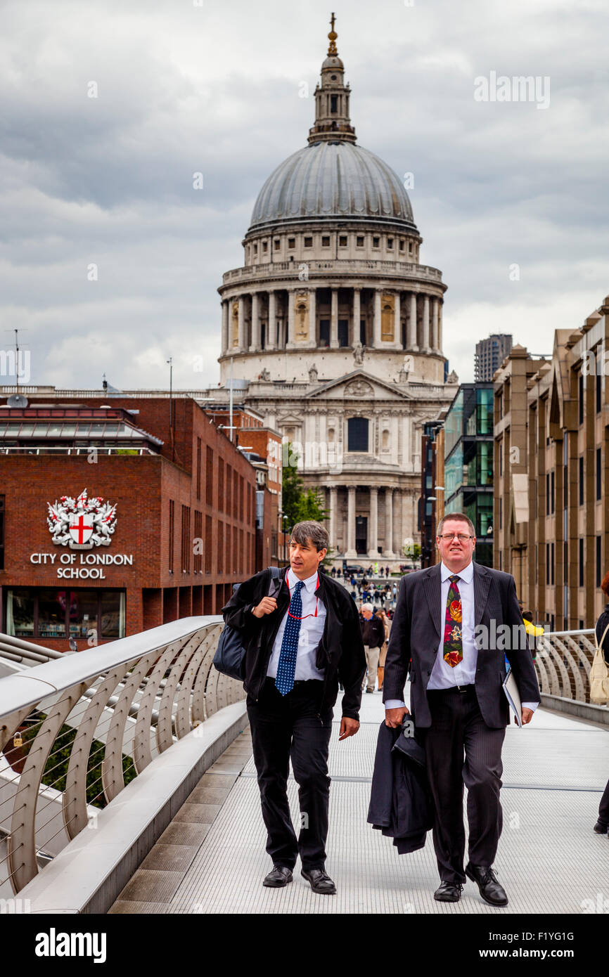 Due uomini di affari in giacca attraversare la passerella del Millennio, Londra, Inghilterra Foto Stock