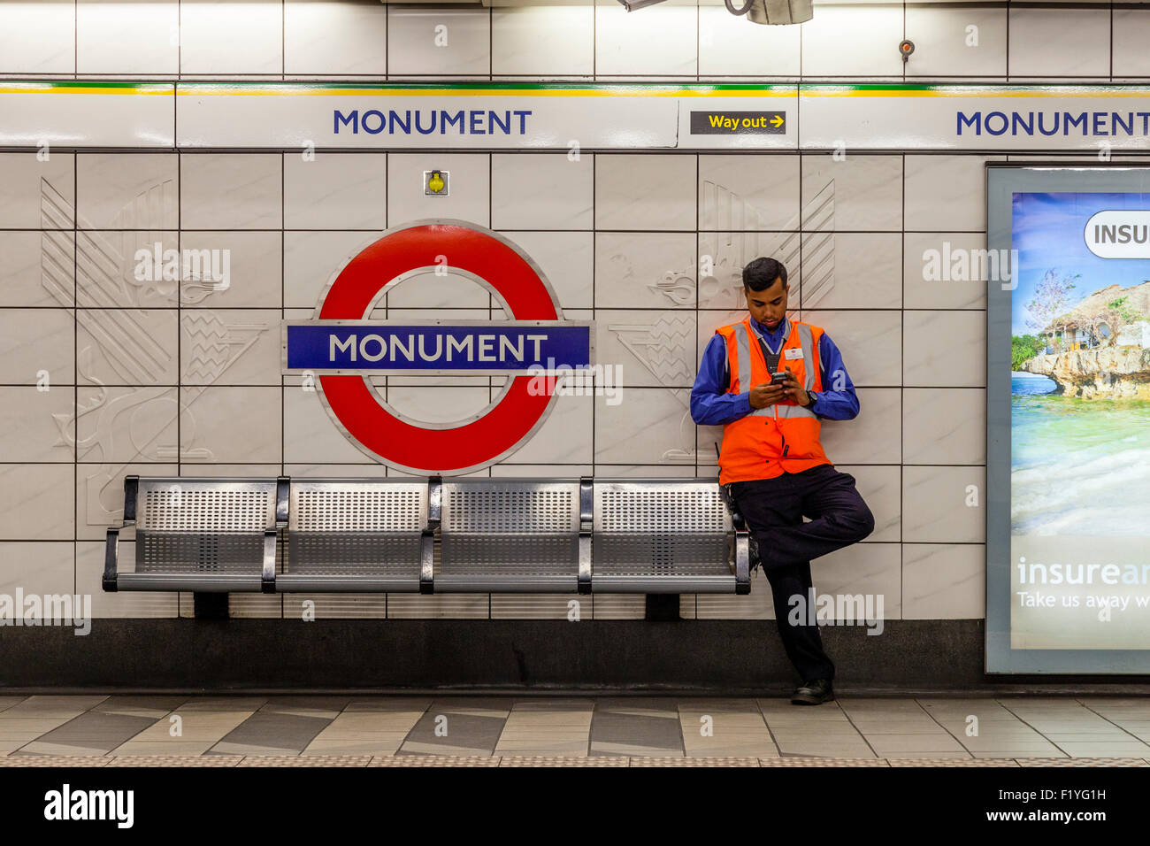 Un metro di Londra lavoratore presso un Monumento Stazione della Metropolitana di Londra, Inghilterra Foto Stock