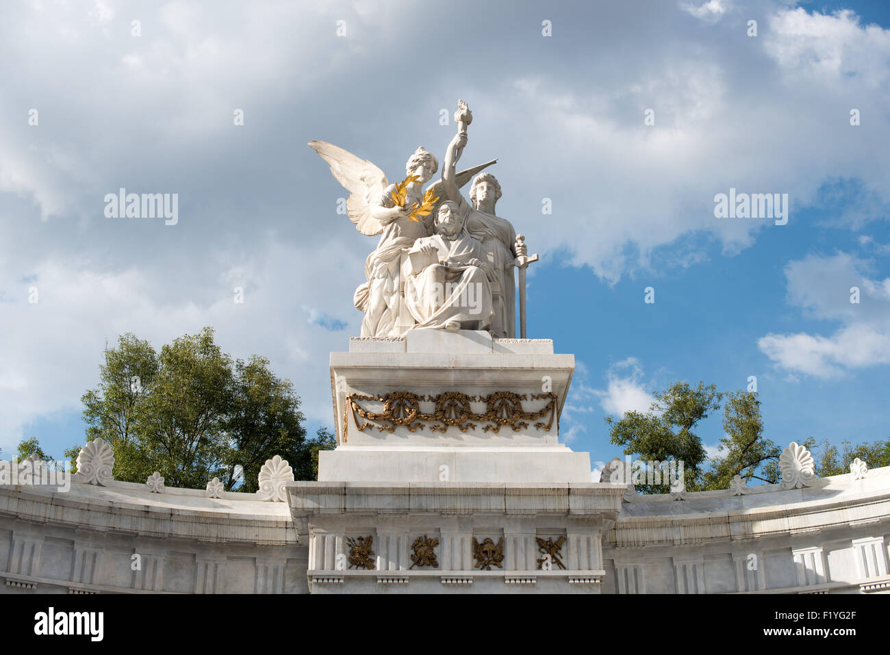 Benito Juárez Monument Alameda Central Mexico City // CITTÀ DEL MESSICO, Messico — Un monumento all'ex presidente messicano Benito Juárez raffigura il leader del XIX secolo che ha servito cinque mandati in carica ed è ampiamente accreditato per aver resistito all'occupazione francese e modernizzato il Messico. Il monumento si trova ad Alameda Central, nel quartiere Centro Histórico di città del Messico. La statua principale, realizzata dallo scultore italiano Lazzaroni, mostra Juárez in posizione seduta. Accanto alla figura centrale ci sono sculture simboliche che rappresentano la patria che viene incoronata, la giustizia che tiene una torcia di gloria e i leoni depositano Foto Stock