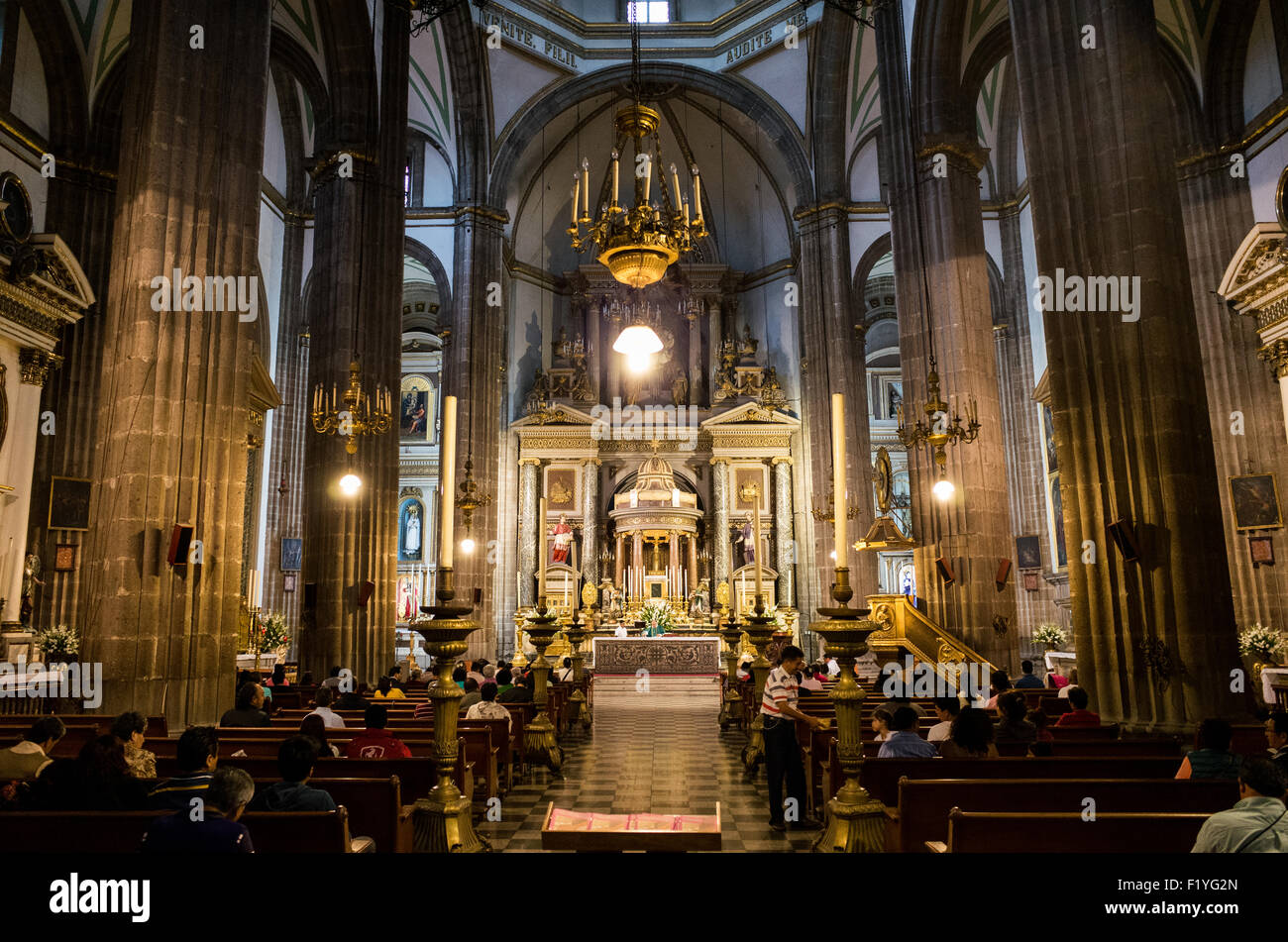 Tempio di San Felipe Neri Altar città del Messico // CITTÀ DEL MESSICO, Messico — la navata principale del Tempio di San Felipe Neri conduce verso l'altare ornato della chiesa nel quartiere Centro Histórico di città del Messico. Spesso conosciuta semplicemente come la Profesa, questa chiesa cattolica romana del XVII secolo fu fondata dai gesuiti ed è stata il luogo di numerosi eventi significativi nella storia messicana. Il tempio si trova nel cuore dell'area del centro di città del Messico, riconosciuta patrimonio dell'umanità dall'UNESCO. Il nome formale della chiesa riflette la sua dedica a San Filippo Neri, il sacerdote italiano del XVI secolo Foto Stock