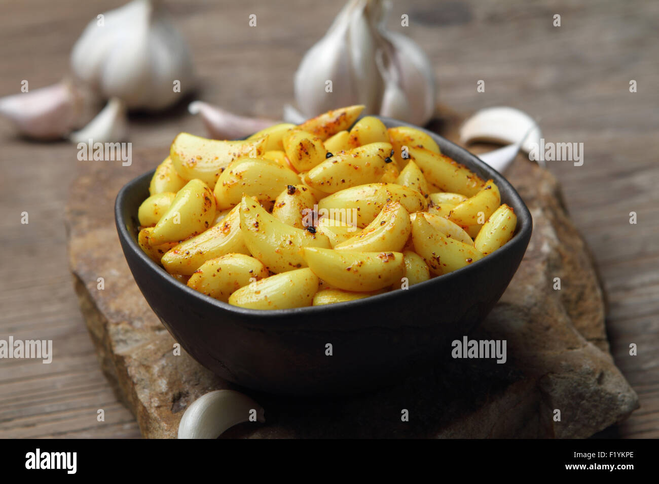 Stile Indiano aglio sottaceto in una ciotola e aglio in background. Foto Stock