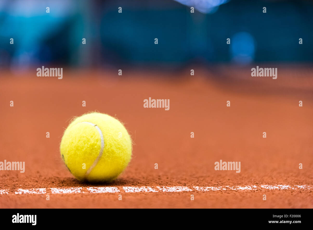 Giallo palla da tennis su una argilla rossa corte Foto Stock
