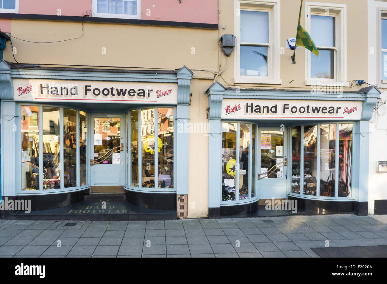 Carrickmacross, nella contea di Monaghan, Irlanda. Vecchia mano negozio di calzature, vendita di scarpe e stivali, dipinto di blu e bianco con curvatura vetrine. Foto Stock