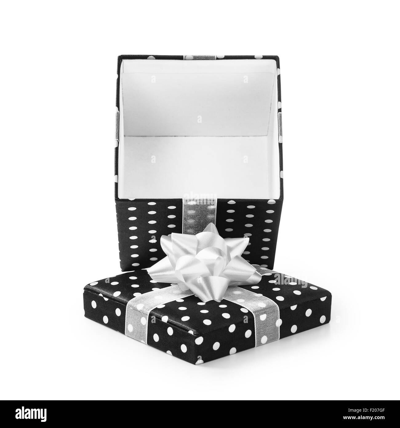 Aprire confezione regalo nera con puntini bianchi e nastro di prua. Holiday presente. Oggetto isolato su sfondo bianco. Tracciato di ritaglio Foto Stock