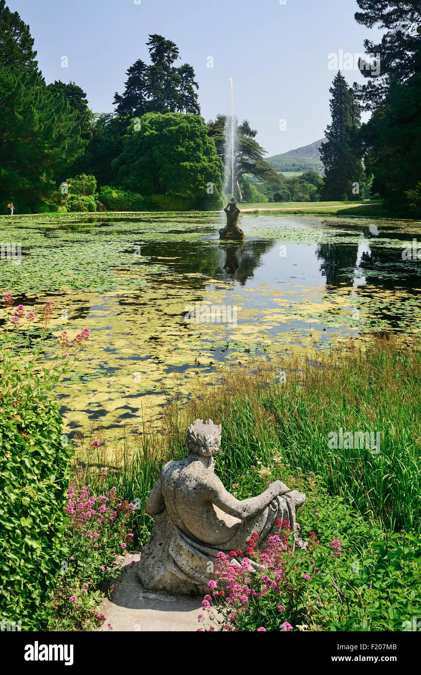 L'Irlanda County Wicklow Enniskerry Powerscourt House e annessi giardini una statua da Triton lago con una fontana nel mezzo di Foto Stock