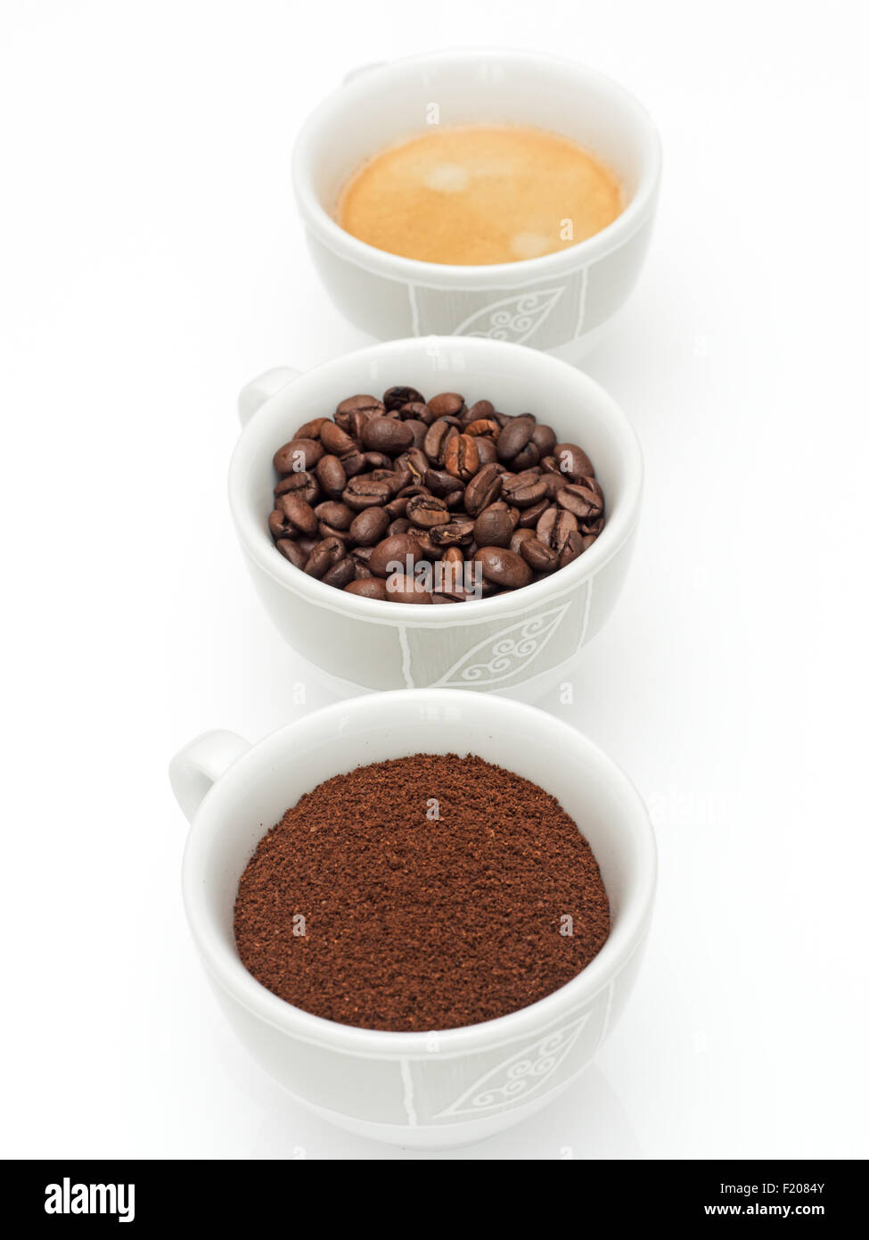 3 Kaffeetassen mit Kaffeepulver, Kaffeebohnen und Kaffee Foto Stock