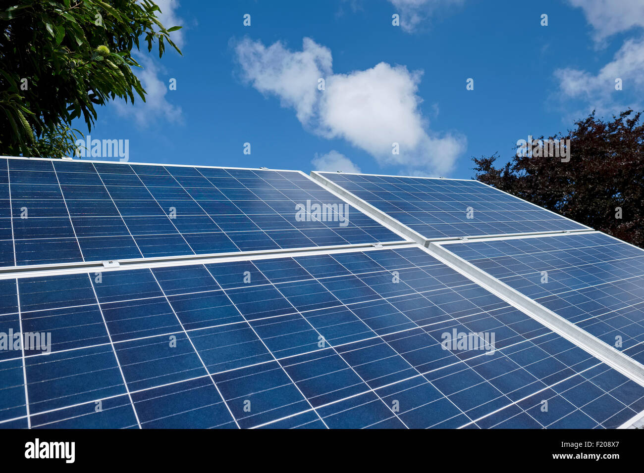 Basato sul terreno i pannelli solari con le nuvole nel cielo blu Foto Stock