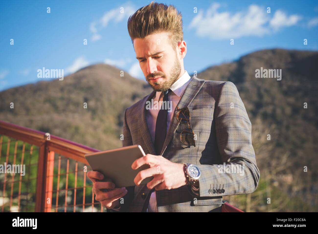 Giovane uomo su passerella la lettura digitale compressa, Rovato, Brescia, Italia Foto Stock
