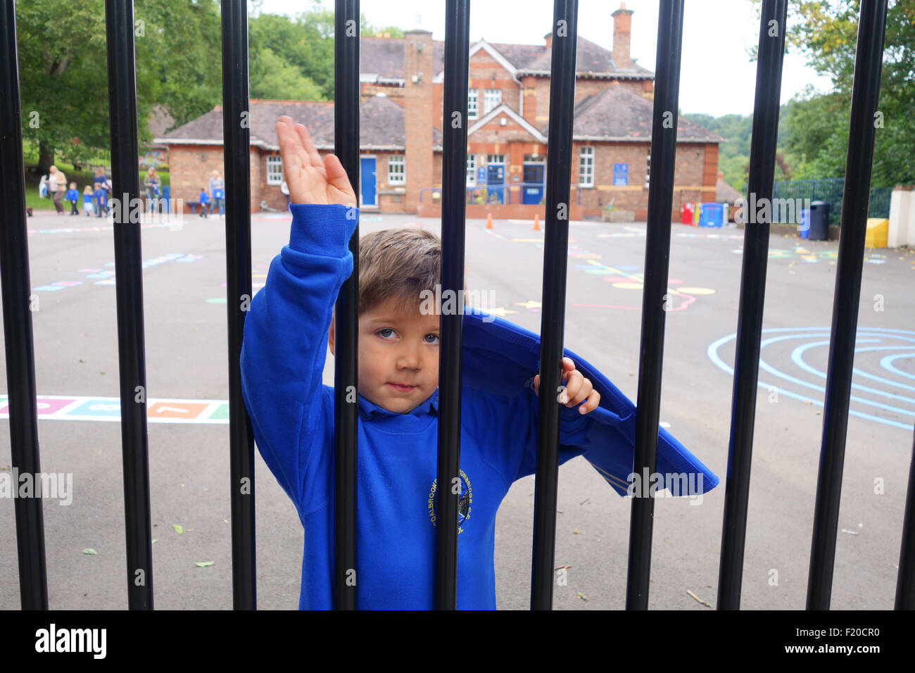 Il primo giorno del rientro a scuola come questo bambino di 4 anni onde addio ai suoi genitori. Si torna a scuola Regno Unito Foto Stock