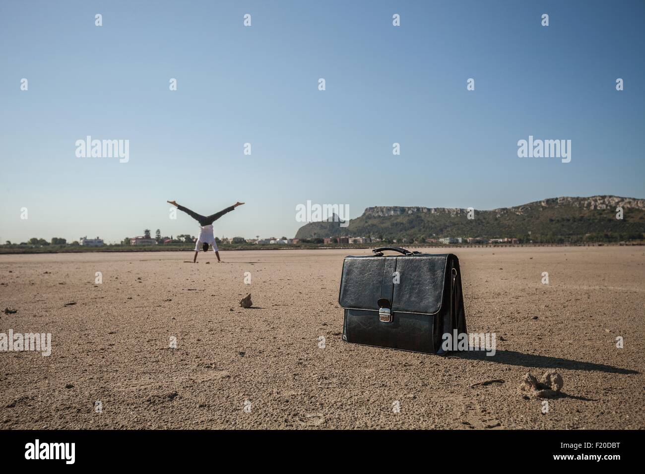 Metà imprenditore per adulti facendo appoggiate sulla spiaggia Foto Stock