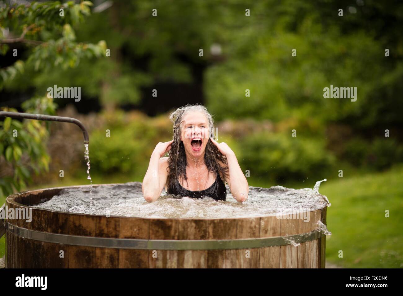 Donna matura in acqua fredda vasca al rifugio eco Foto Stock