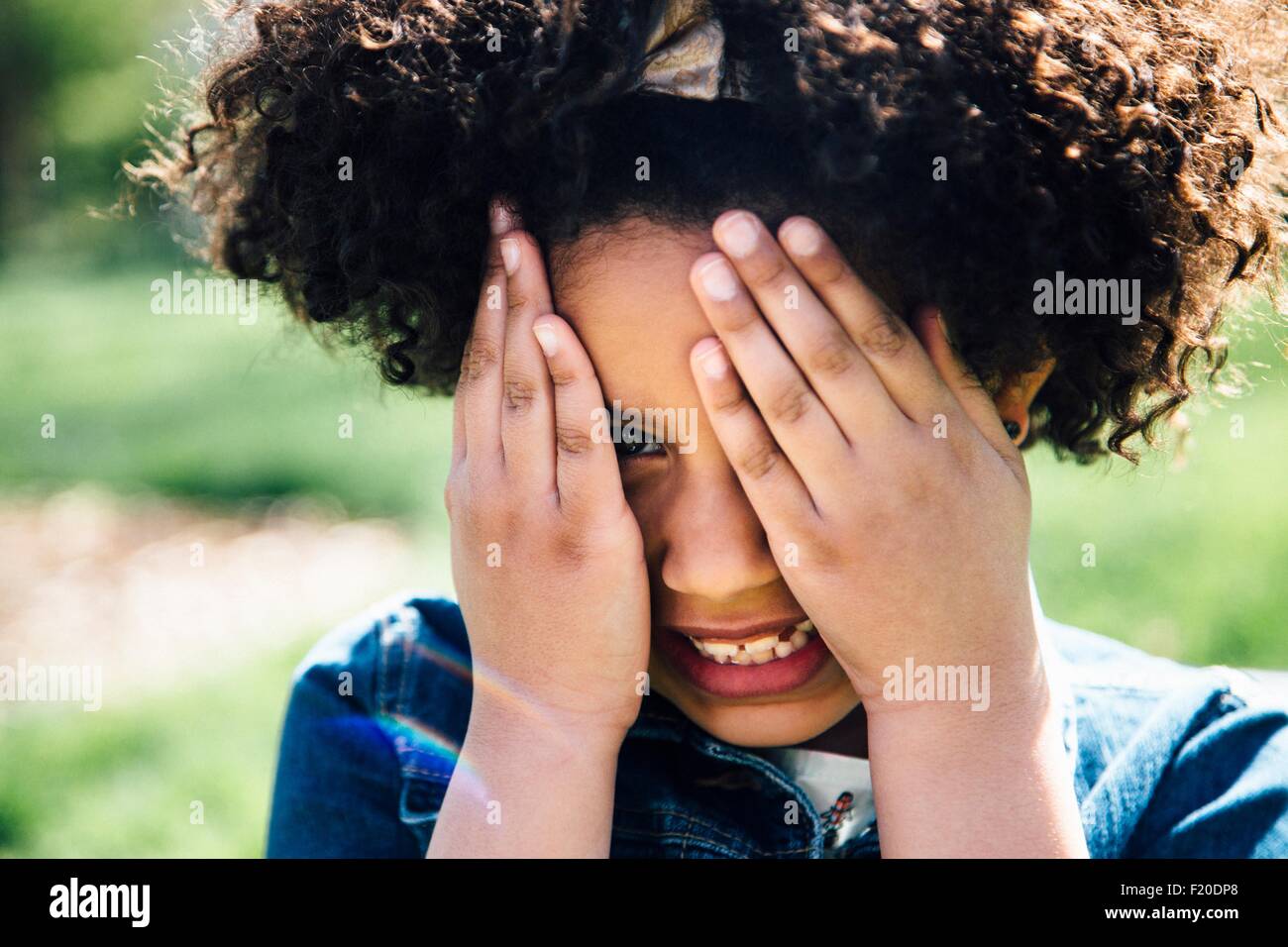 Close up ritratto della ragazza che ricopre la faccia con le mani Foto Stock