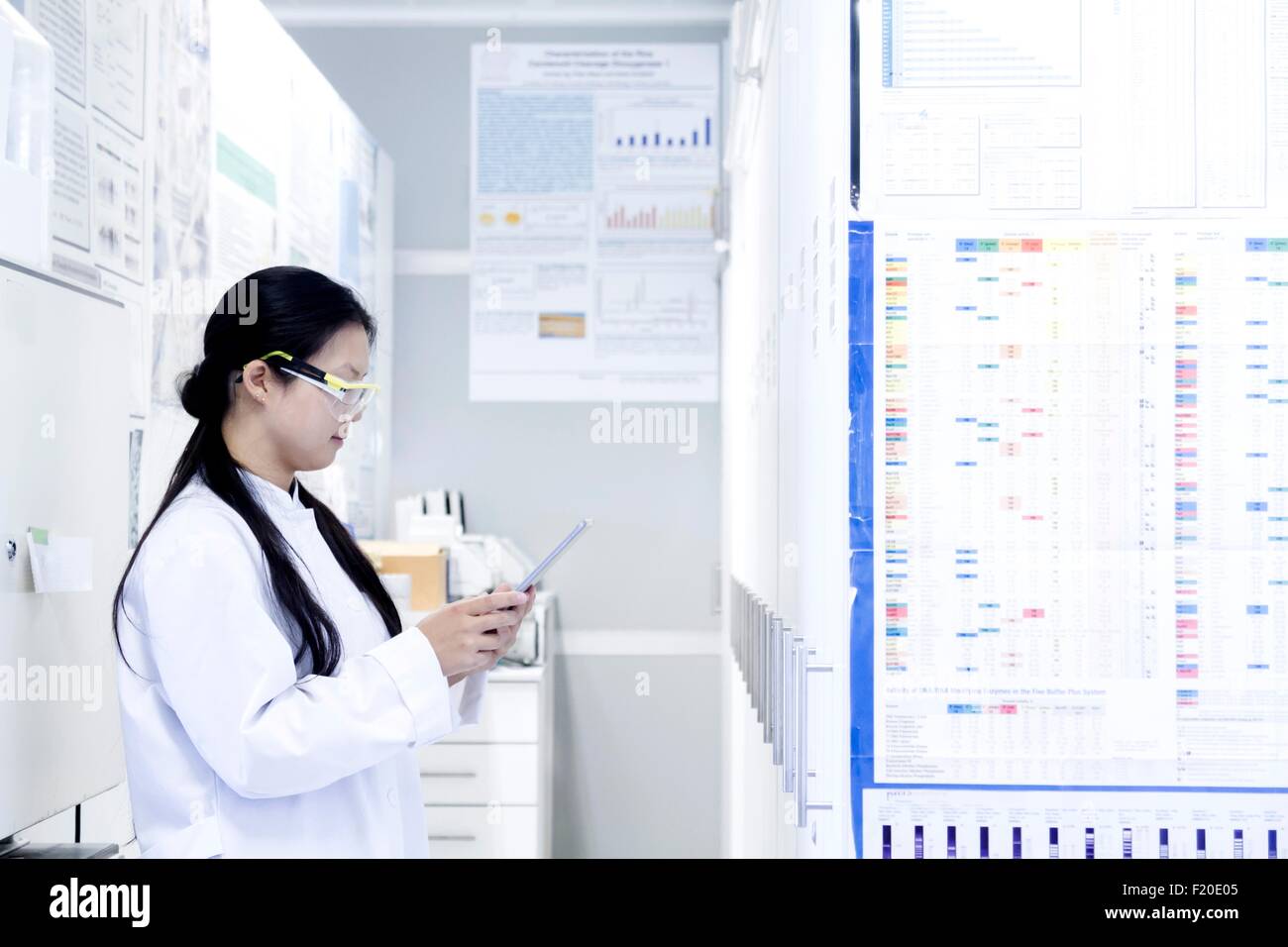 Donna scienziato guardando digitale compressa in laboratorio Foto Stock