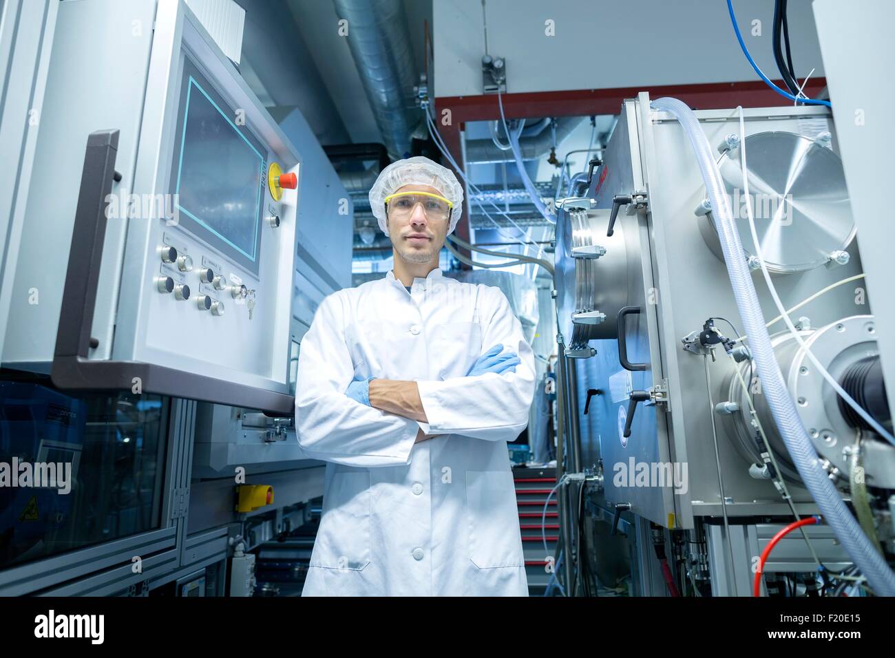 Ritratto di uno scienziato maschio con i bracci ripiegati in lab cleanroom Foto Stock