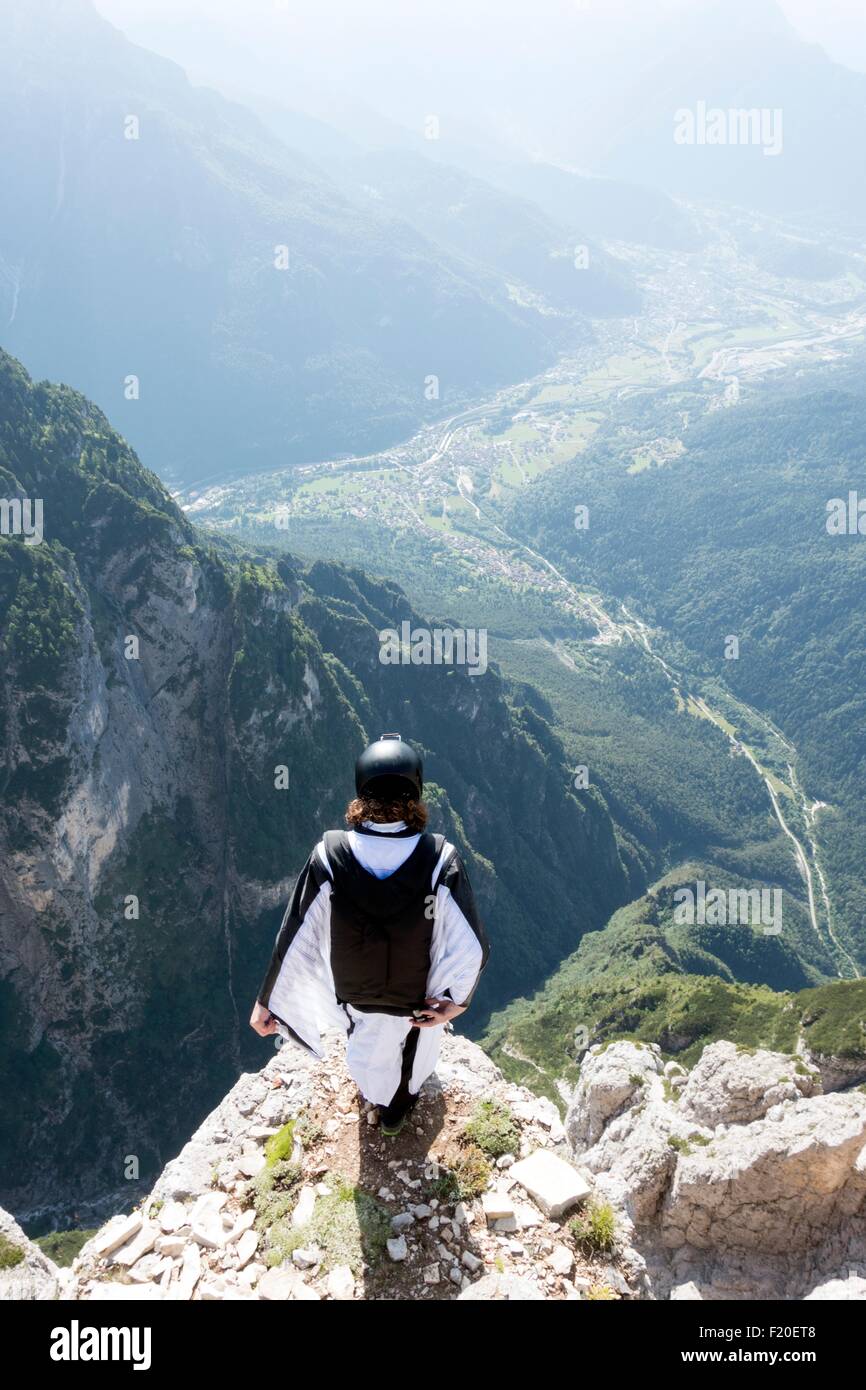 Maschio a ponticello di base in wingsuit in piedi sul bordo della Montagna, Dolomiti, Italia Foto Stock