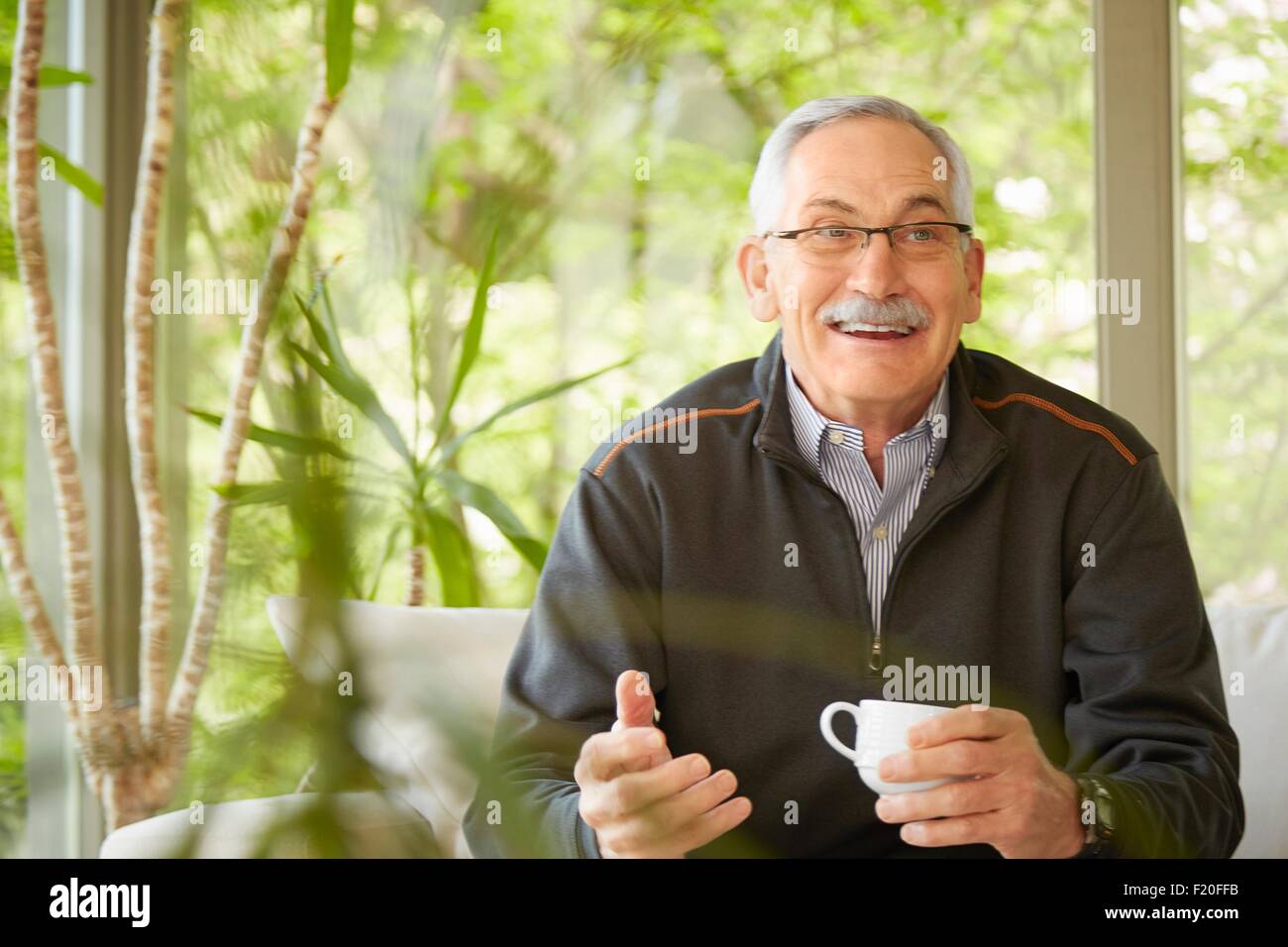 Senior uomo a casa a bere caffè Foto Stock