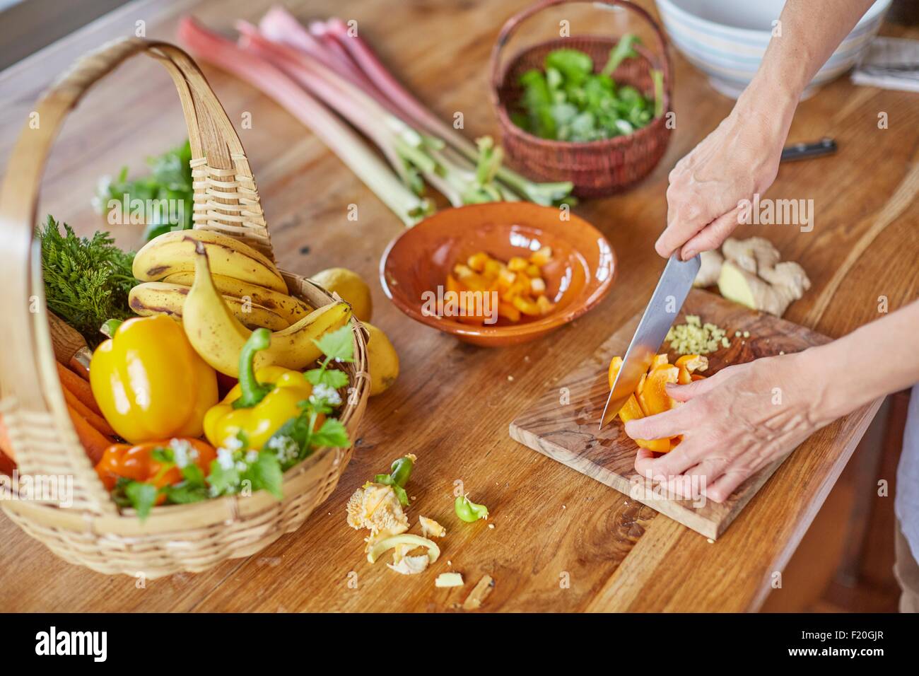 Donna matura tritare verdure, concentrarsi sulle mani Foto Stock