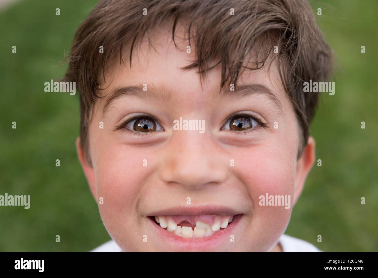 Ritratto di giovane ragazzo che sorride, mostrando di gap dal dente perduto Foto Stock