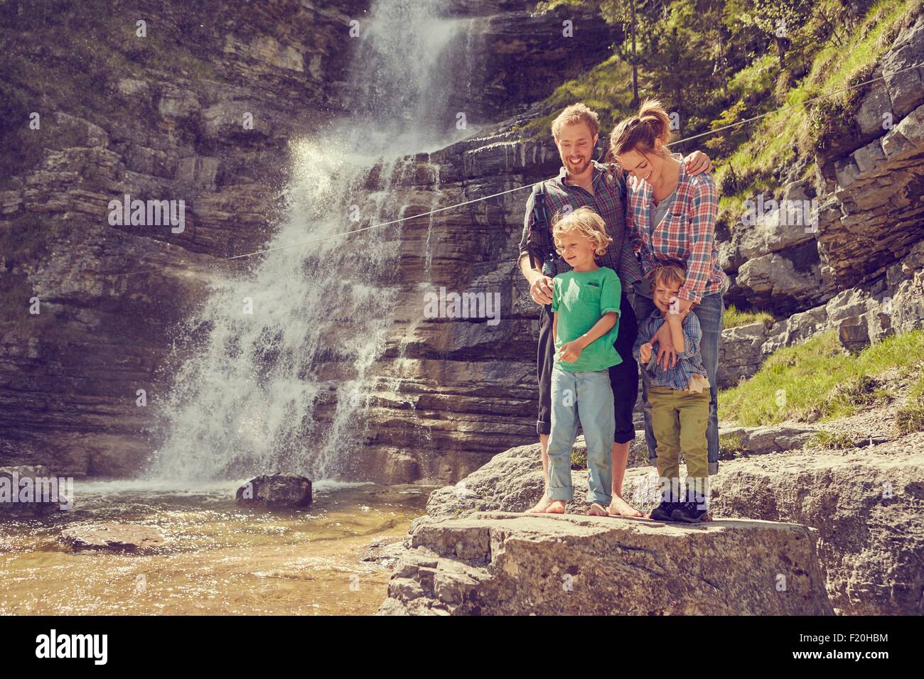 Due generazione famiglia avente divertimento con cascata, Ehrwald, Tirolo, Austria Foto Stock