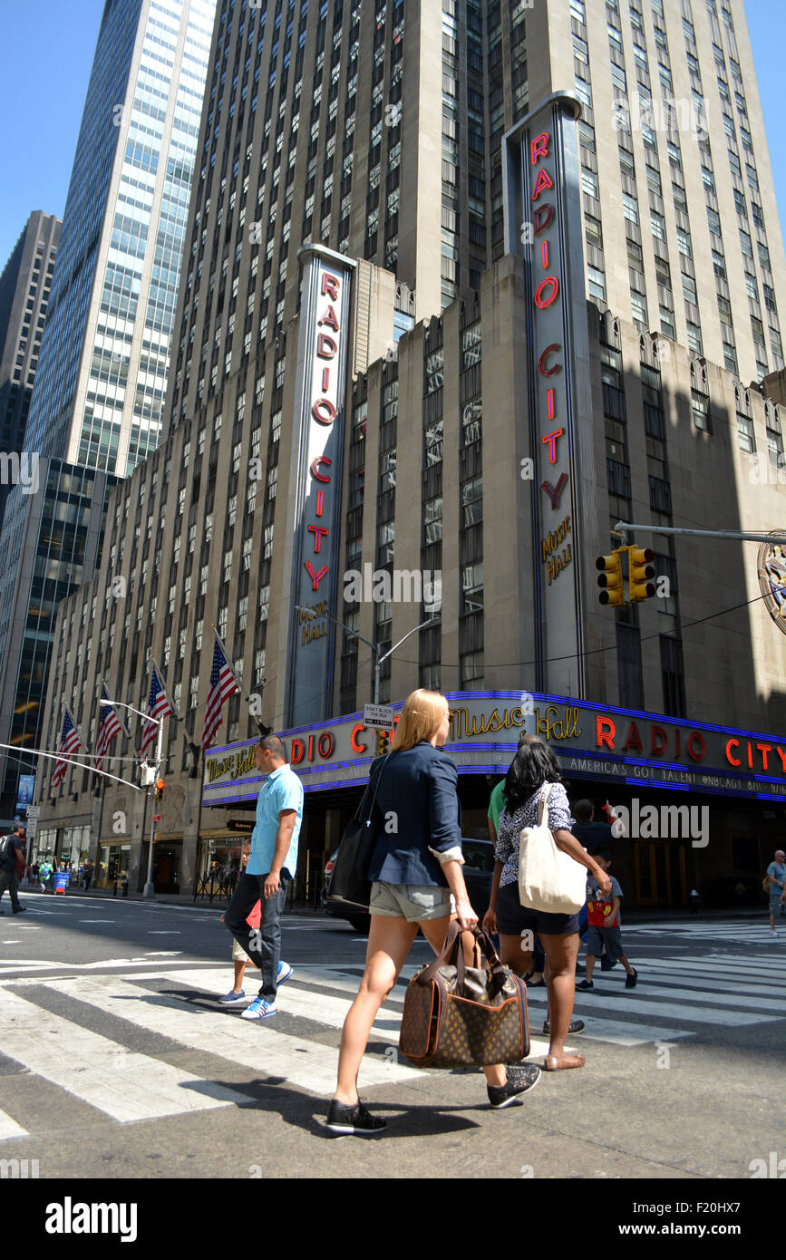 Le persone che attraversano le Sesta Avenue davanti al Radio City Music Hall in Midtown Manhattan. Foto Stock