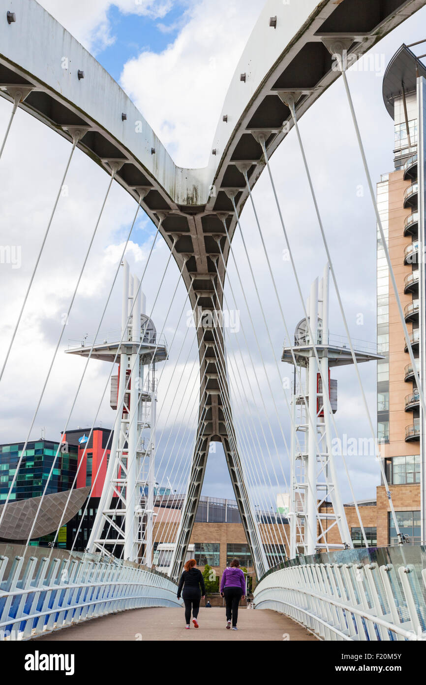 Le persone che attraversano il Salford Quays ponte di sollevamento anche noto come il Lowry Bridge o Millennium footbridge, Salford Quays, Manchester, Inghilterra, Regno Unito Foto Stock