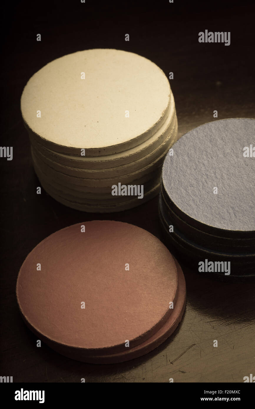 Vintage antique poker chips in bianco, blu e rosso impilati su un tavolo di legno. Foto Stock