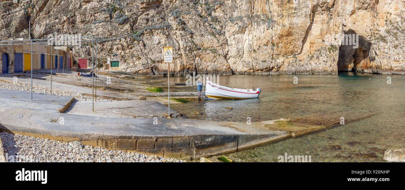 Malta, Gozo, Dwejra Inland Sea e vista panoramica su un mare interno oltre che un pescatore prepara la sua barca per passare da Foto Stock