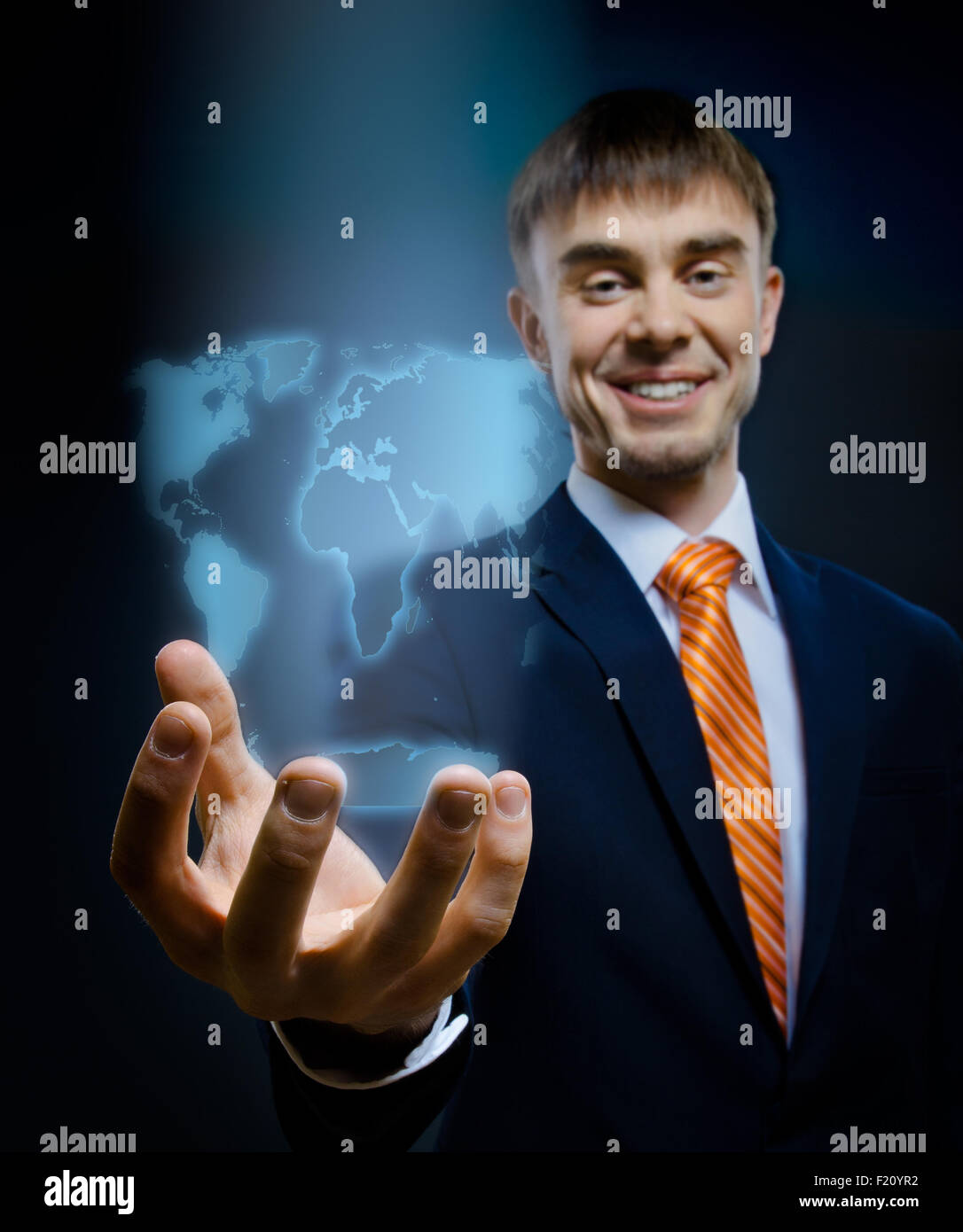 Imprenditore tenere in mano globo terrestre, su sfondo blu scuro, concetto di business Foto Stock
