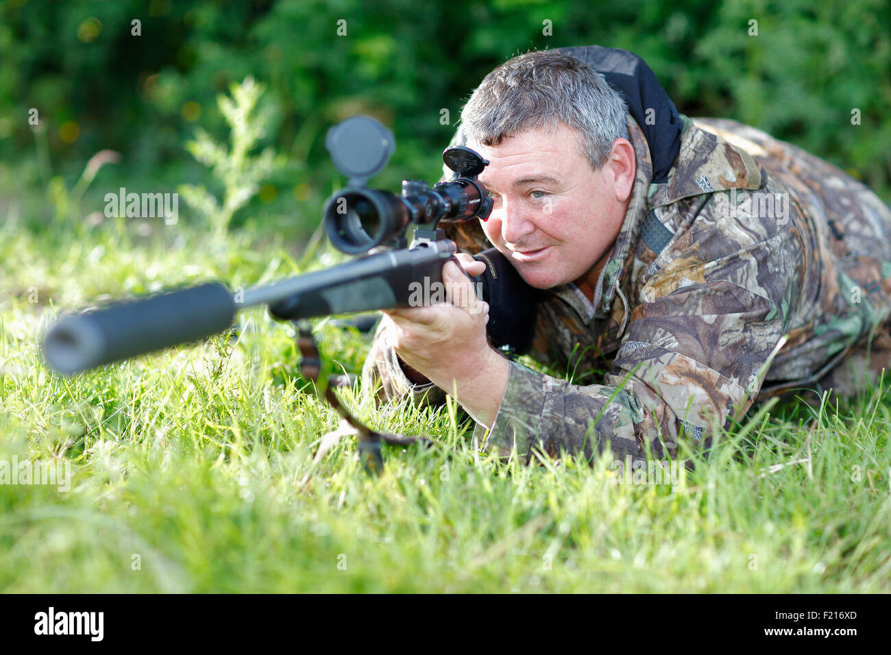 Sport, Gun, tiro, Sniper indossando camoflage fucile di contenimento con un potente campo di applicazione e la riduzione del rumore la museruola. Foto Stock