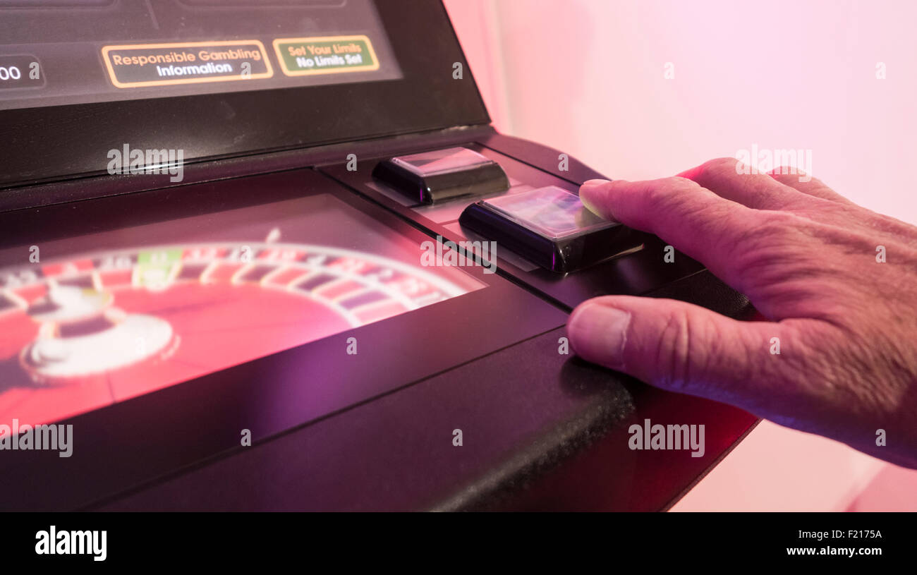 L'uomo gioca su fixed odds roulette macchina in Bookmakers. Regno Unito Foto Stock