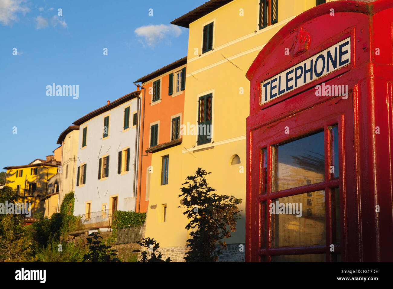 L'Italia, Toscana, Lucca, Barga, British telefono box con facciate delle vecchie case di città in background. Foto Stock