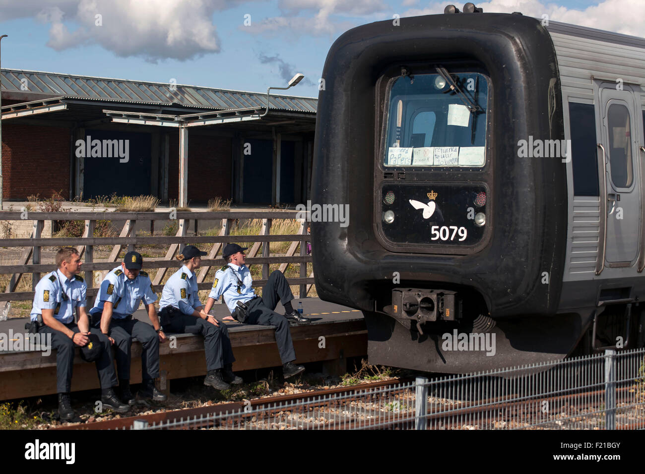 Roedby, Danimarca, Settembre 9th, 2015. La polizia circonda i due treni del porto di Roedby con alcuni 240 rifugiati che vuole chiedere asilo in Svezia. È loro negato il transito attraverso la Danimarca e la polizia li richiedono fuori dei treni. La strategia di polizia è stato il dialogo e non con la forza. Credito: OJPHOTOS/Alamy Live News Foto Stock