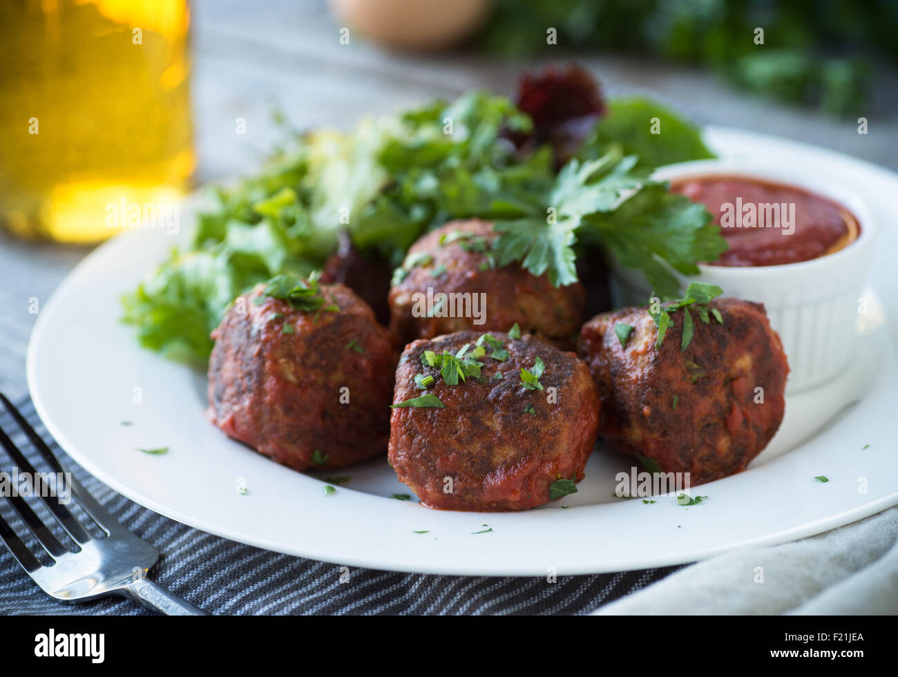 Deliziose polpette di carne con insalata verde e salsa di pomodoro Foto Stock