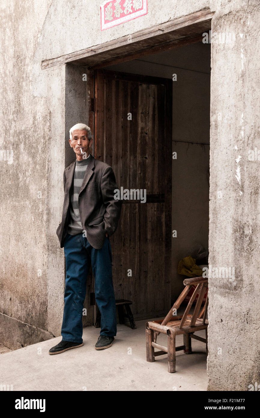 Coppia senior uomo fumare in una porta, Nanping village, provincia di Anhui, Cina e Asia Foto Stock
