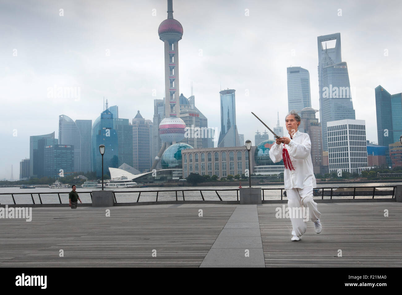 Senior Asian uomo vestito di bianco le pratiche di esercizi di spada all'aperto, il Bund, Shanghai, Cina e Asia Foto Stock