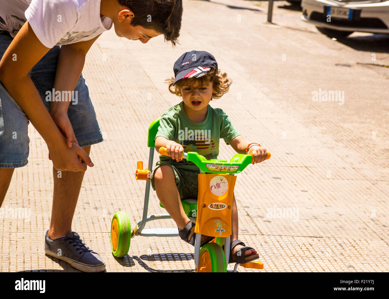 Uomo di consigliare little boy sulla moto del pedale in Lecce Puglia Italia Foto Stock