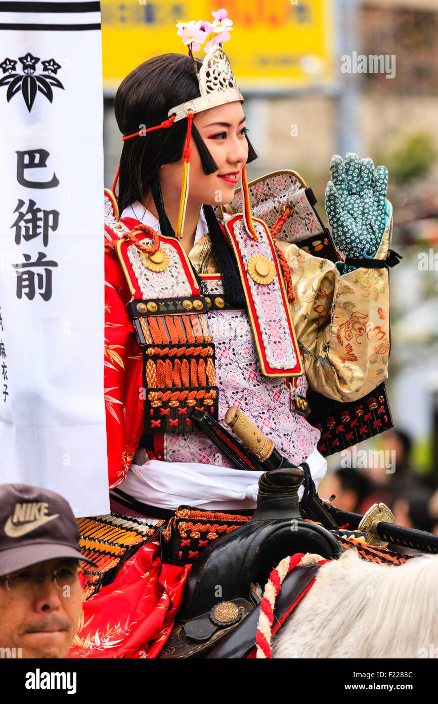 Genji festival parade in Giappone. Close up della giovane donna a cavallo, vestito in armatura samurai con un piccolo periodo Heian corona sul capo, salutando la folla. Foto Stock