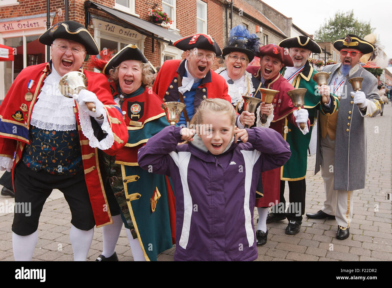 Katie Carr, all'età di sette anni, mette le sue dita nelle sue orecchie per arrestare il noideg della città Criers concorso a Thetford, Norfolk. Settembre 2015 Foto Stock