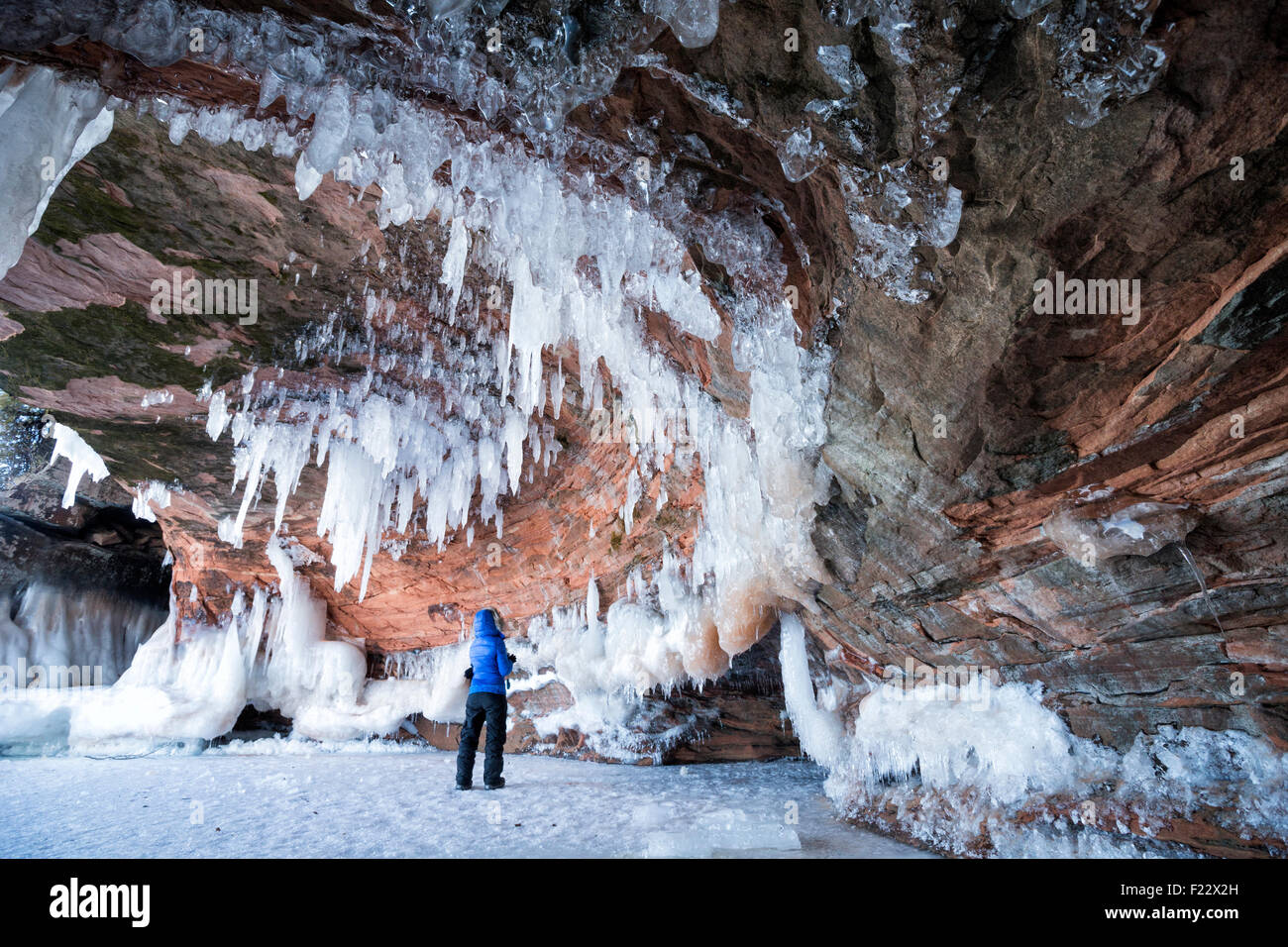 Una persona in piedi sotto il soffitto di pietra arenaria di una caverna di ghiaccio all Apostolo Island National Lakeshore, Cornucopia, Bayfield County, Wi Foto Stock