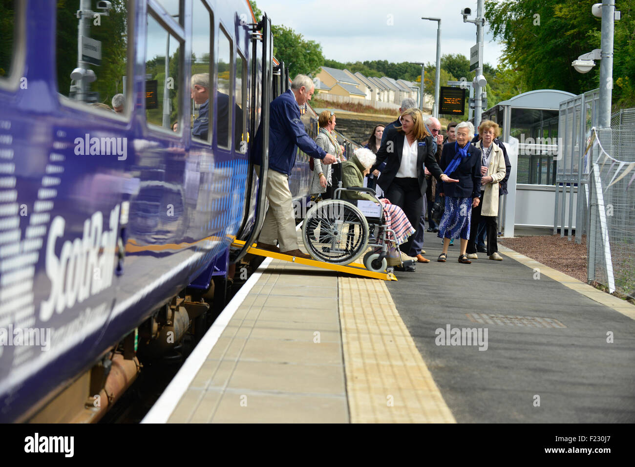 Disabili passeggeri del treno su una sedia a rotelle di sbarco di un treno. Foto Stock