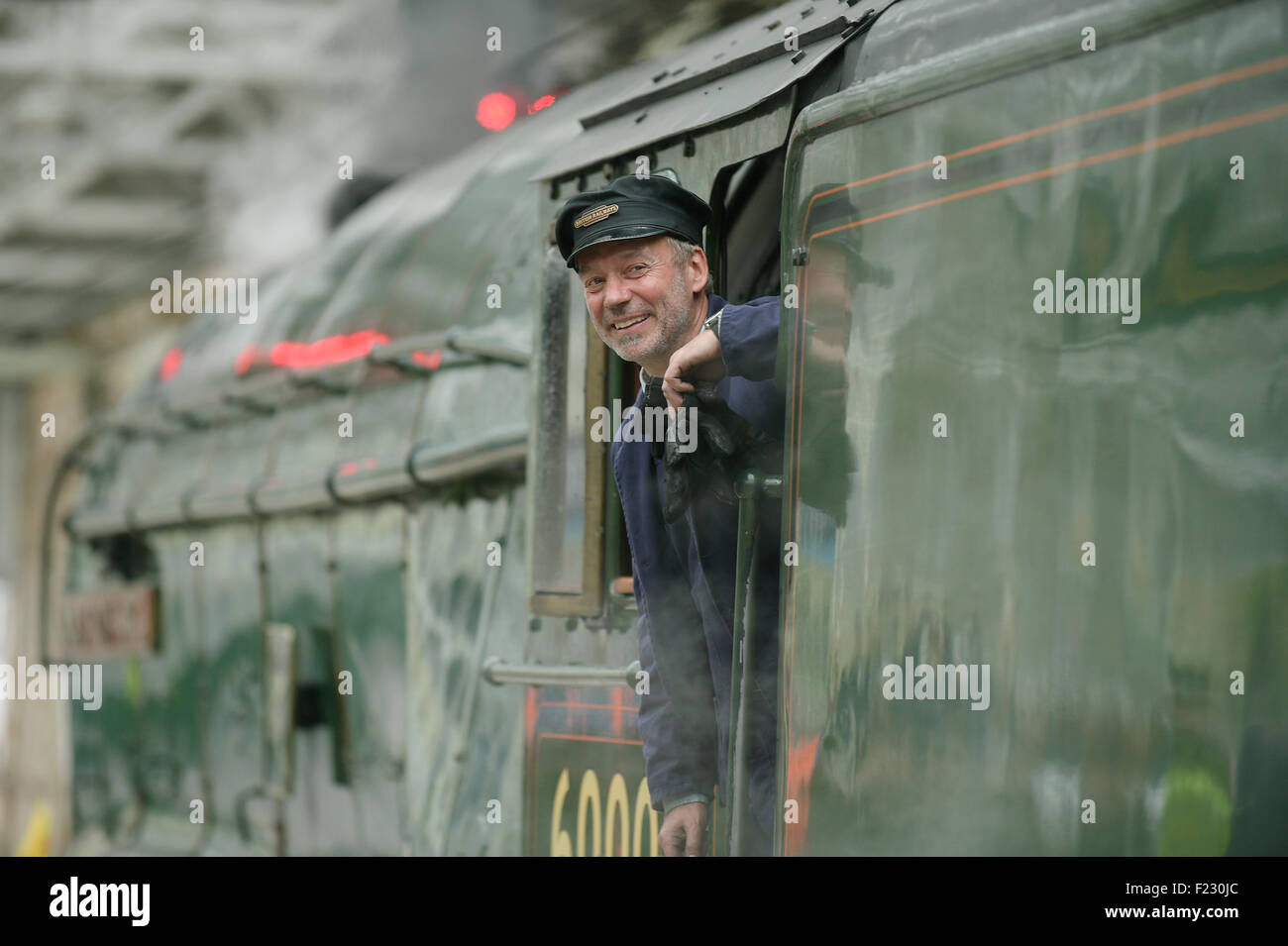 Treno a vapore conducente guardando fuori la sua cabina. Foto Stock