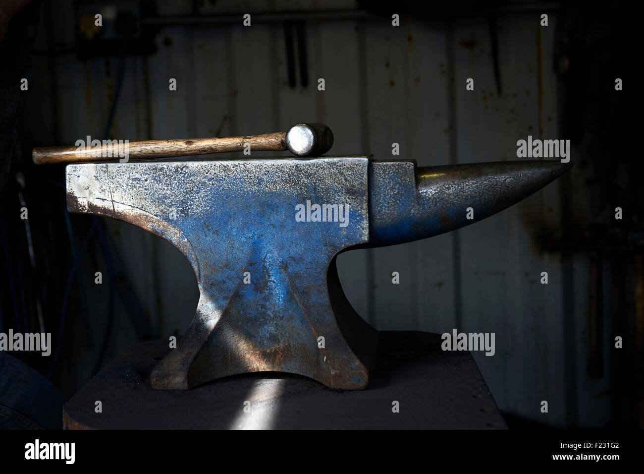 Martello giacente su una incudine di ferro in un tradizionale la fucina di fabbro ferraio di. Foto Stock