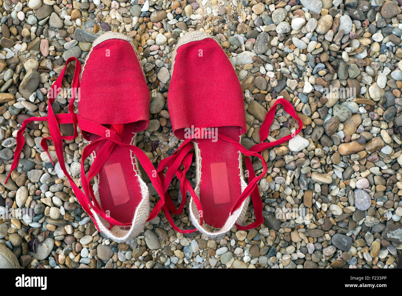 Pantofole rosse su un pavimento di ciottoli Foto Stock