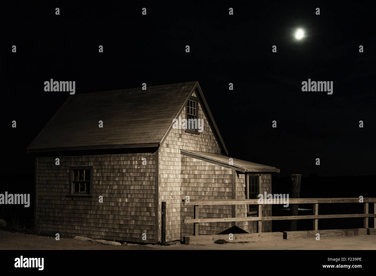 La luna piena splende su moody shanty costiere. Foto Stock