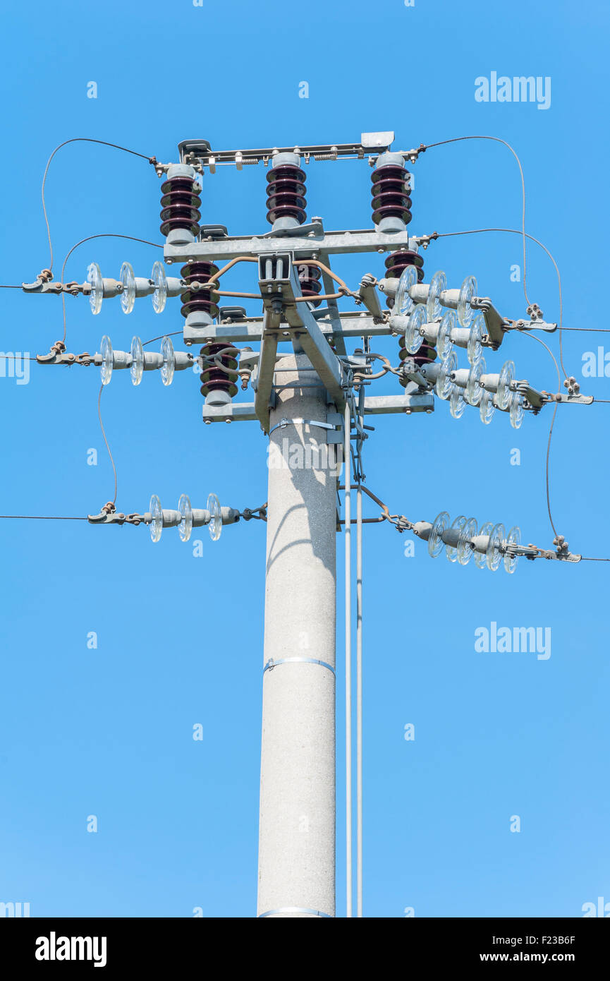 Alimentazione interruttore sezionatore manuale sul pilone elettrico contro il cielo blu Foto Stock